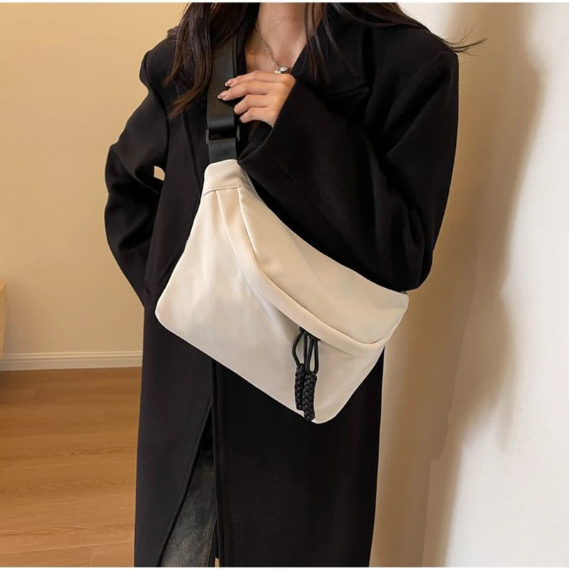 Quadratische Umhängetasche in neutraler Farbe für Damen und Herren, mit schlichtem Design, geeignet zum Tragen auf Reisen oder für den Arbeitsgebrauch.