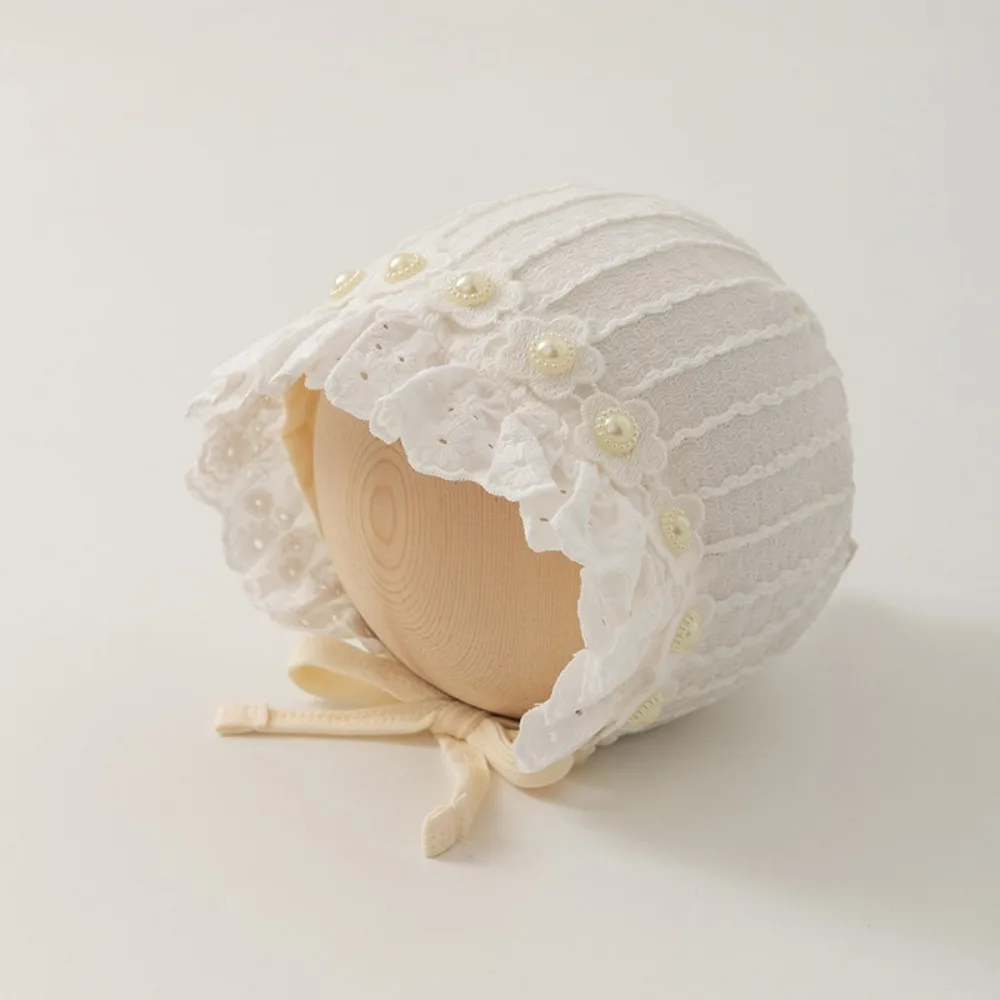 

Детская шапочка-чепчик с кружевной отделкой, жемчугом и оборками, дышащая, из хлопка, однотонная, мягкая, с цветочными оборками, для защиты ушей младенца
