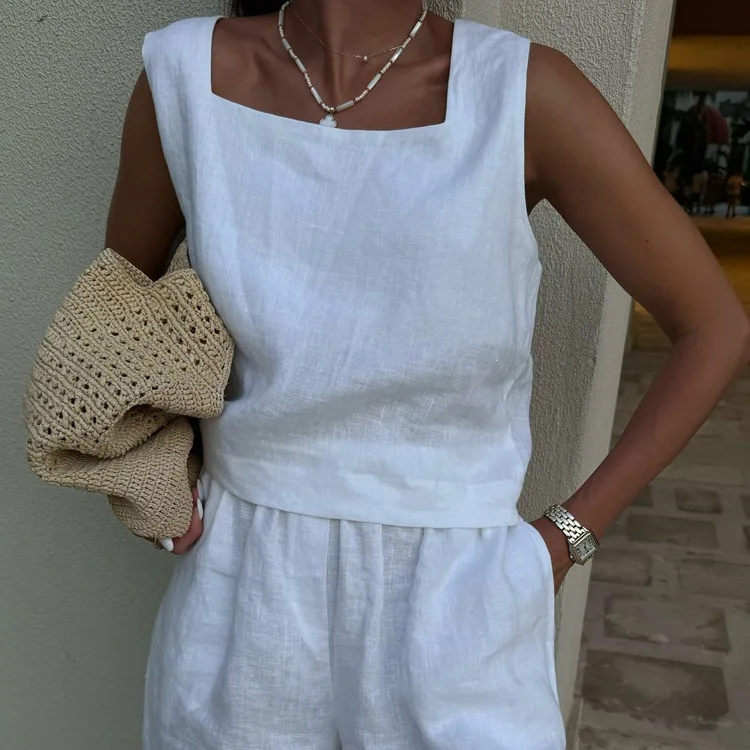 

Летний модный комплект из белого хлопка: элегантная блузка без рукавов с квадратным вырезом и шорты с высокой талией и карманами.