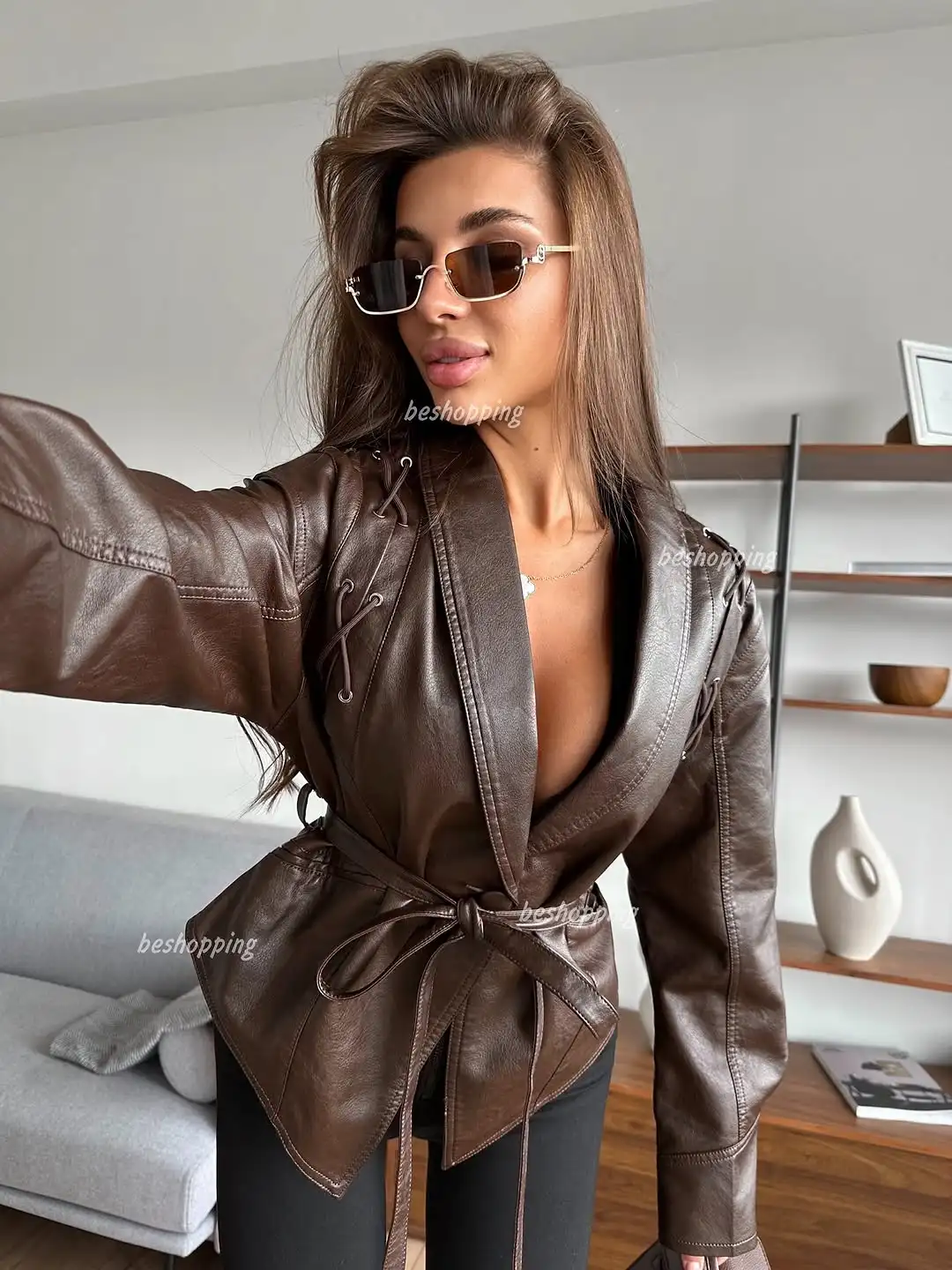 Krótka skórzana kurtka damska sznurowana, dopasowany krój, dekolt w serek, podkreślająca talię, jesienna moda damska, casualowa odzież wierzchnia w stylu streetwear.