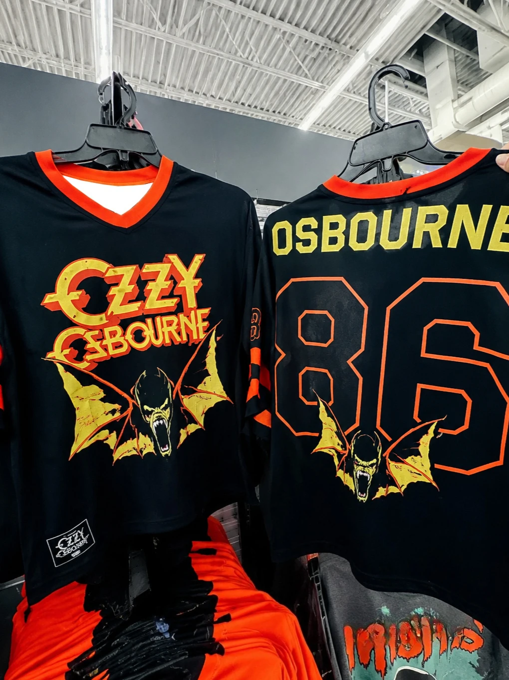 Camiseta deportiva holgada con cuello en V, de malla, estilo jersey de fútbol, con estampado de letras rockeras vintage de murciélago de terror desgastado, en colores burdeos, dorado y con mangas multirrayas.