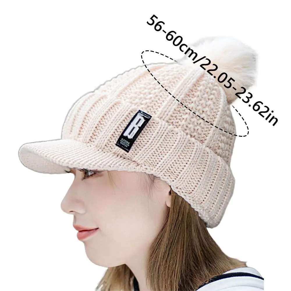 قبعة محبوكة عصرية دافئة سميكة مع كرات فرو قبعة شتوية مقاومة للرياح لحماية الأذن للنساء