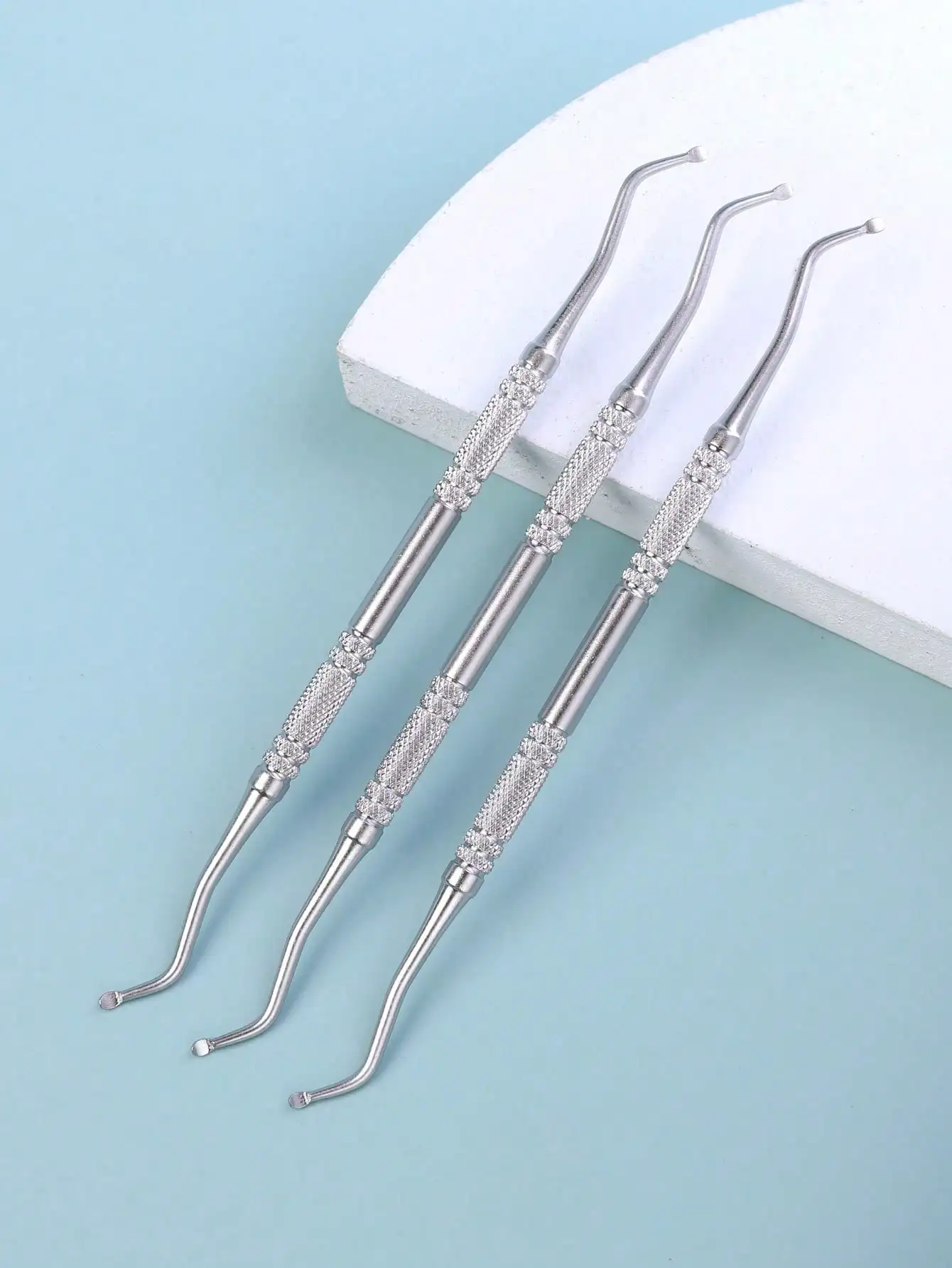 3 pieces of stainless steel cuticle remover, with a specialized nail embedding knife inserted deep into the nail groove