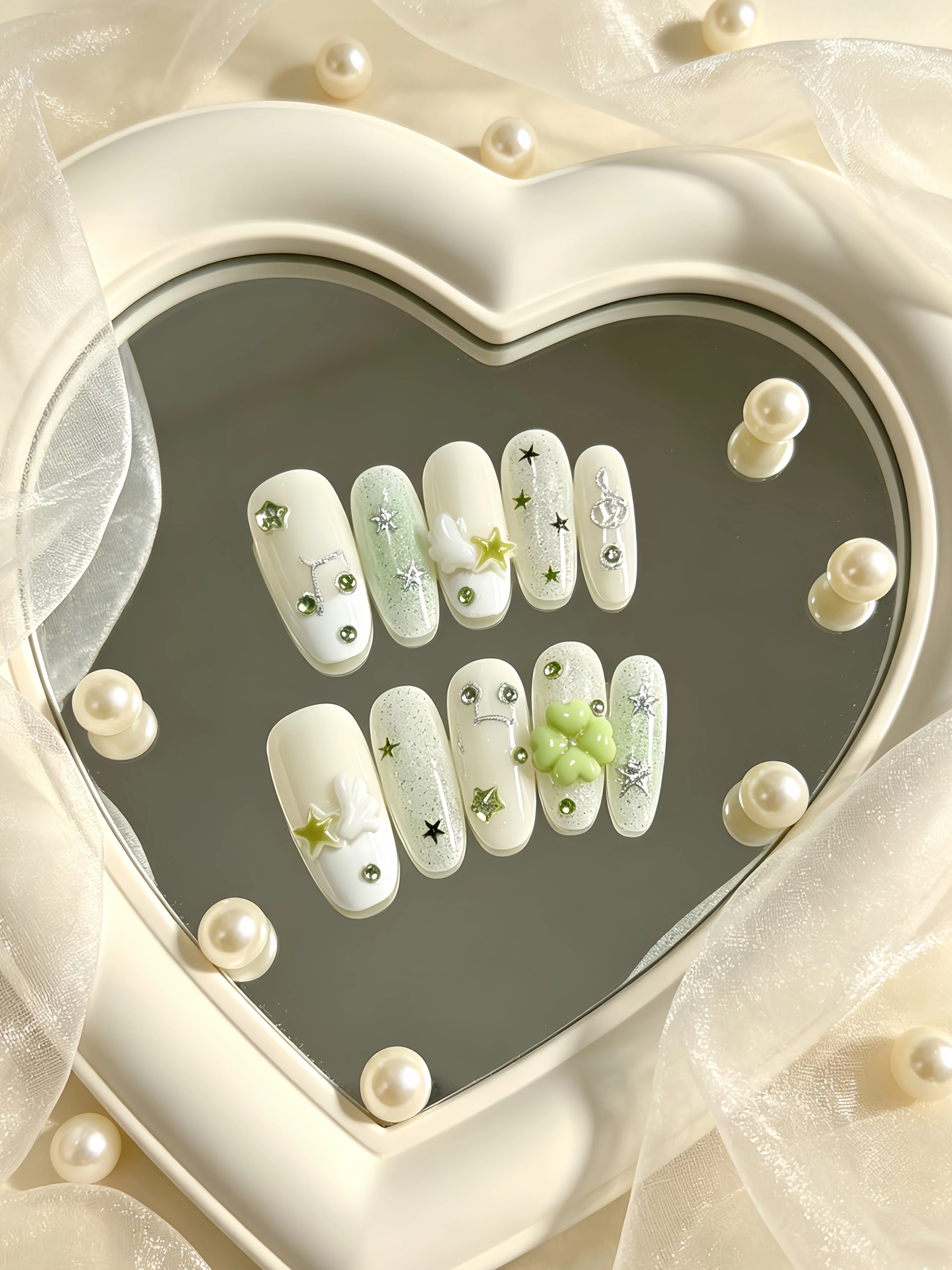 10 Pieces of Medium-Length Oval-Shaped Wearable Nails, Featuring a Fresh and Simple Design with Milk White and Light Green Gradient, Silver Glitter Stars, Rhinestones, Musical Notes, 3D Four-Leaf Clover Wings, and Five-Pointed Stars Embellishments