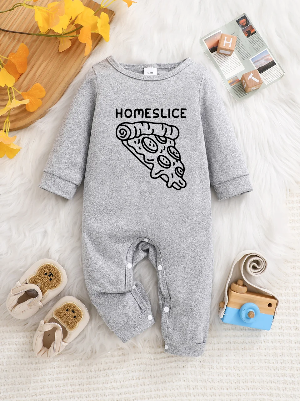 A baby long-sleeved onesie with interesting letter prints. It features a buttoned design for easy putting on and taking off
