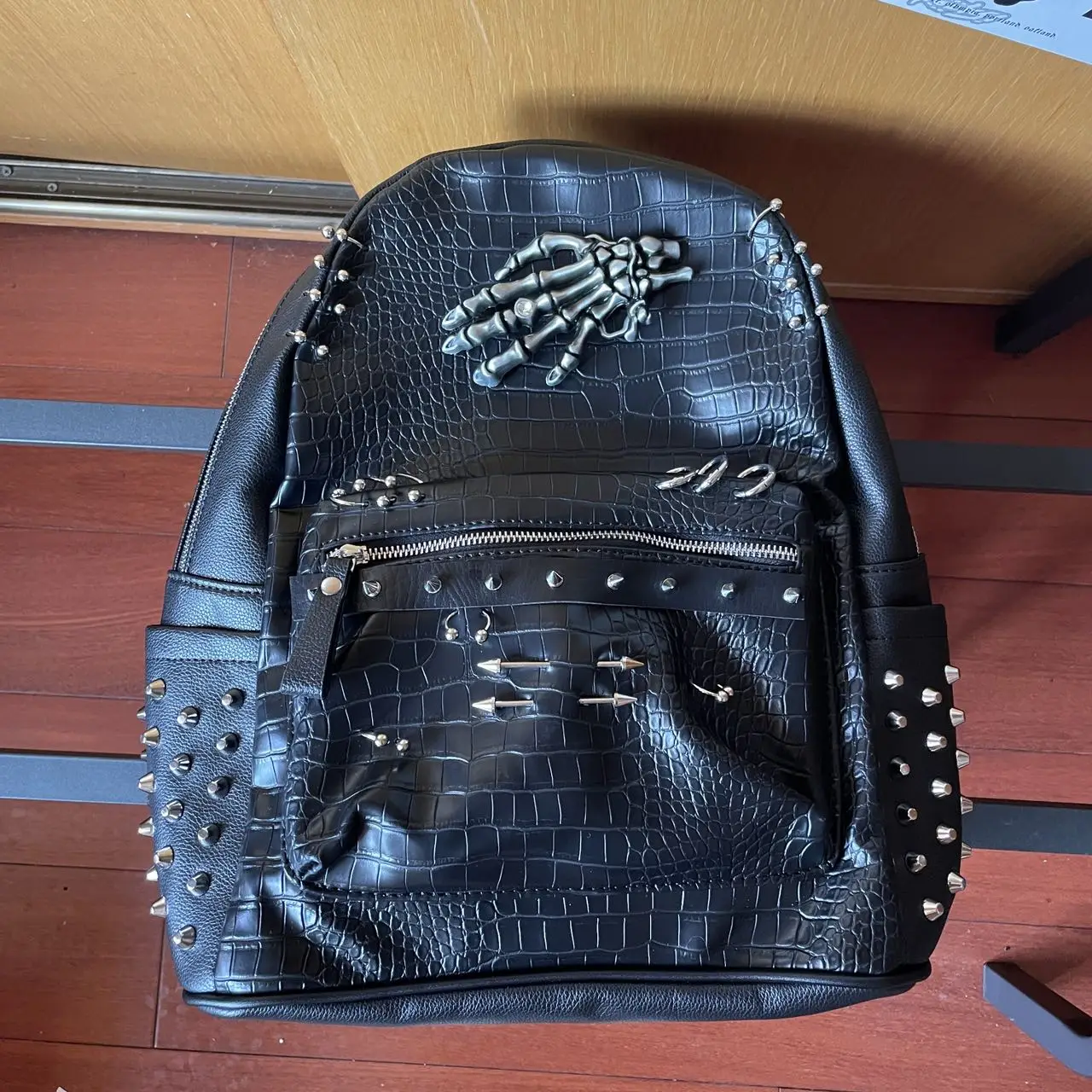 sac-a-dos-en-similicuir-noir-texture-crocodile-rivets-style-punk-avec-ornement-main-squelette-en-metal-design-original