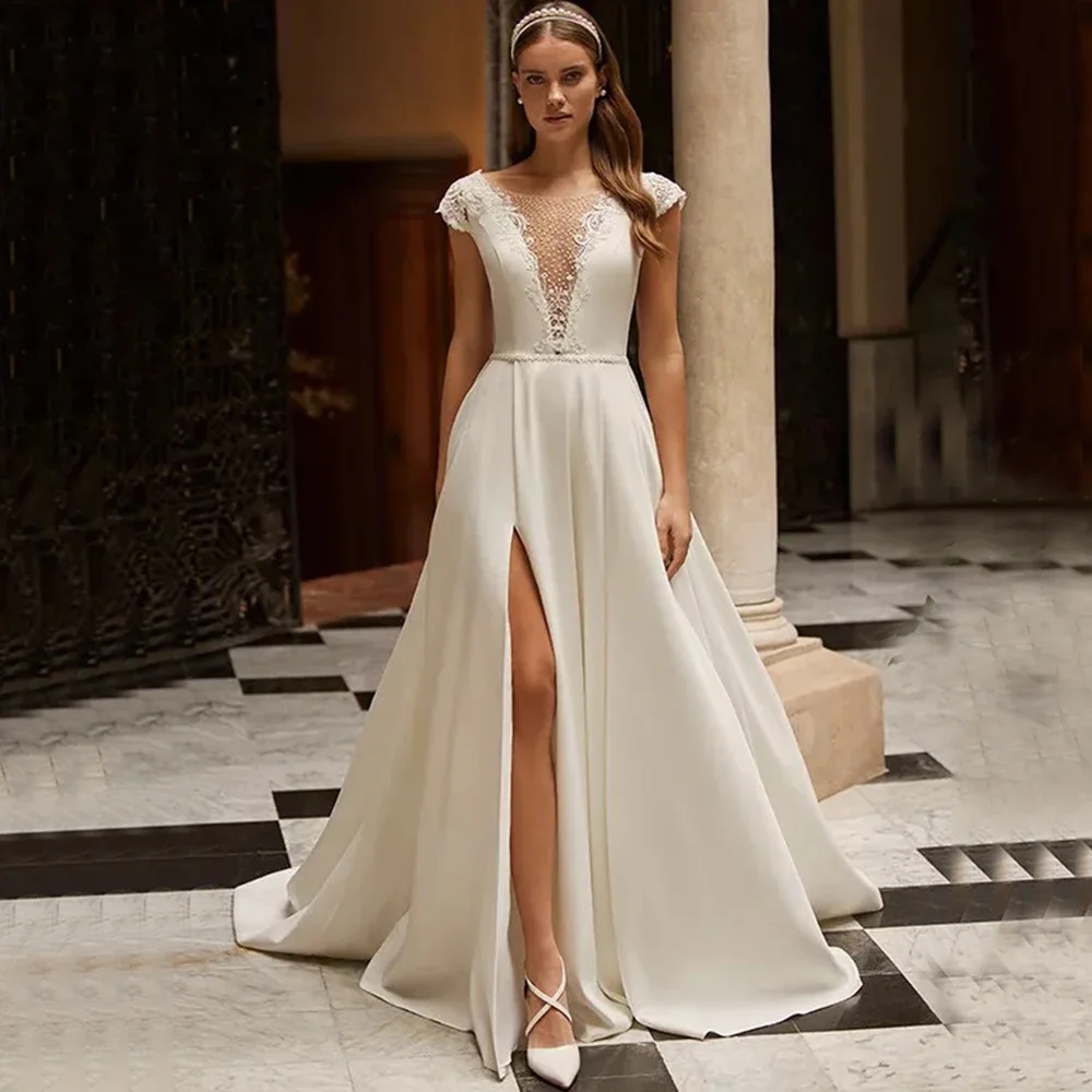 

Винтажное свадебное платье А-силуэта с рукавами-крылышками, боковым разрезом, аппликациями и бисером, длиной в пол, с иллюзорной спинкой и шлейфом.