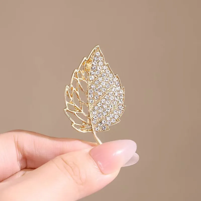 بروش فاخر مرصع بالألماس المتلألئ على شكل أوراق ذهبية يفتح نمط أنيق رائع يعرض الملمس الراقية ورائع