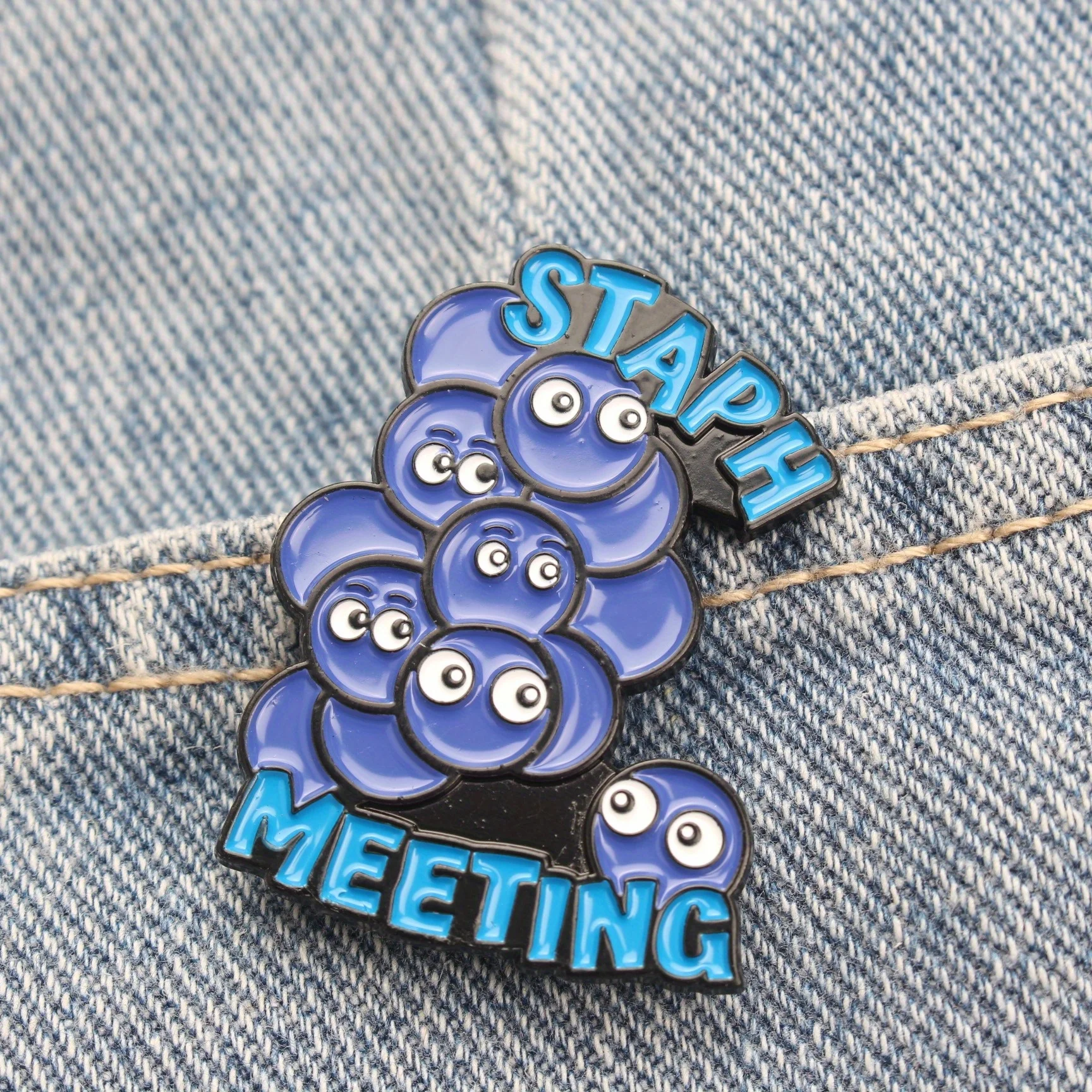 The MEETING STAPH brooch—a creative and humorous fashion accessory—makes an excellent gift for friends.