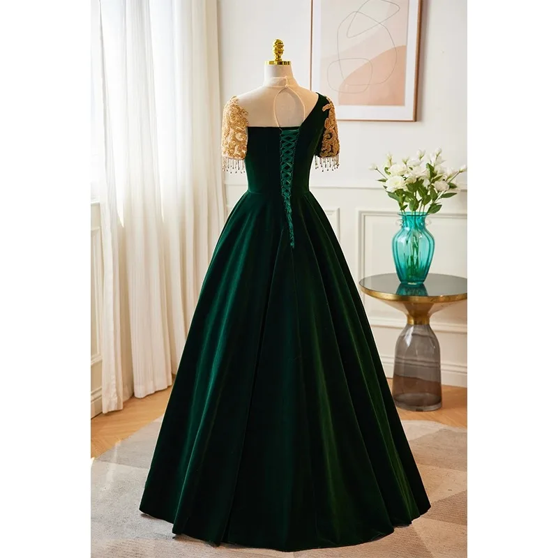 Ciemnozielona suknia wieczorowa, damska suknia na występ fortepianowy, elegancka atmosfera, wyszukana suknia do występów folkowych.