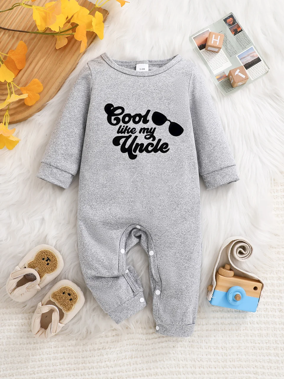 A baby long-sleeved onesie with interesting letter prints. It features a buttoned design for easy putting on and taking off