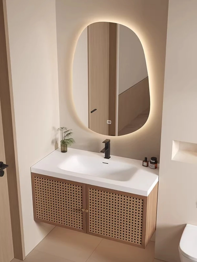 

Комбинация мебели для ванной в стиле средневекового ваби-саби: тумба из массива дерева с интегрированной раковиной из Corian и умывальник из ротанга.