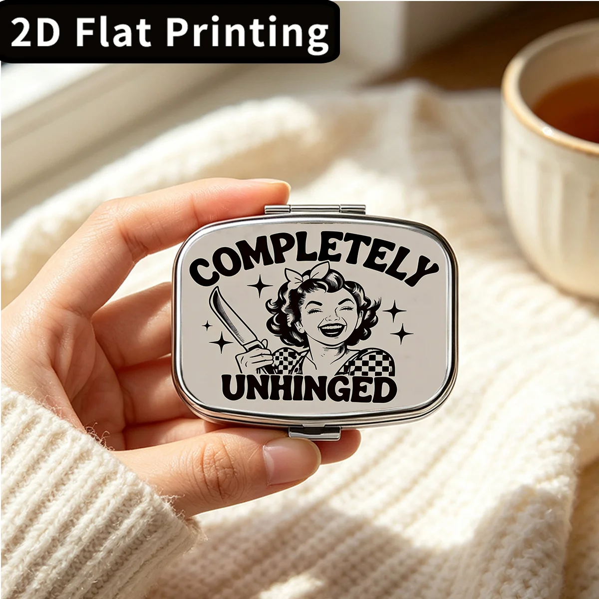 Flat-printed metal pill box with a woman holding a knife motif - compact two-compartment pill organizer, suitable for travel and use in a wallet, pill box, fashion accessory, flat design