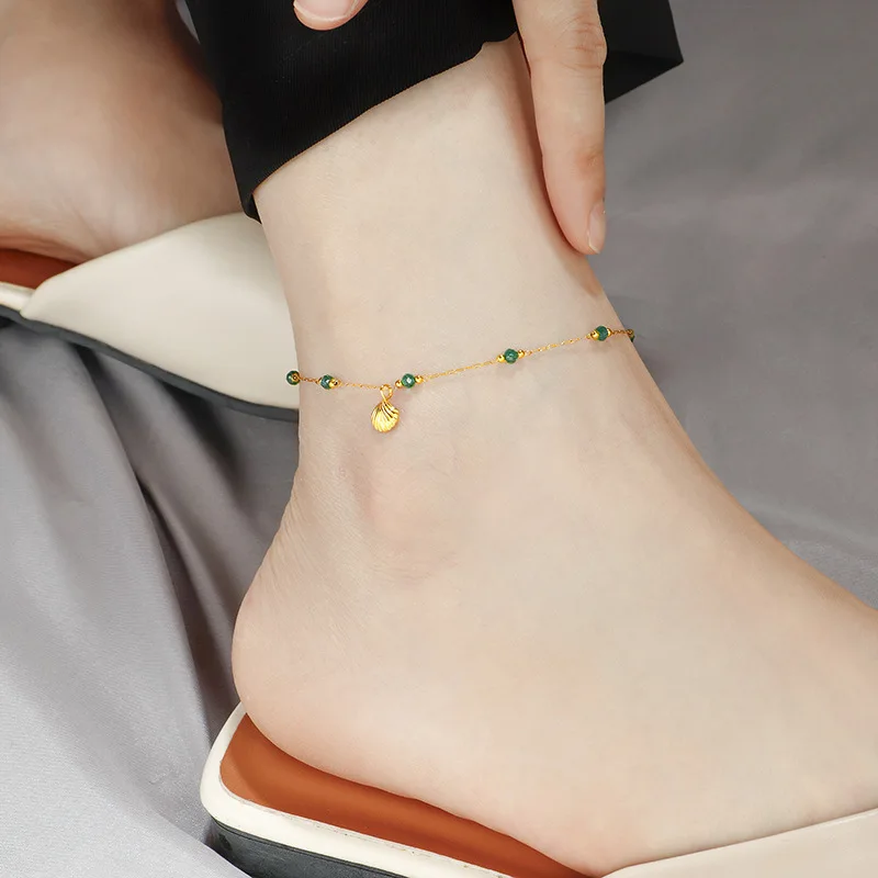 Tornozeleira feminina Jinhui com design moderno e exclusivo, banhada a ouro, novidade de verão 2024, em aço titânio com contas de esmeralda.