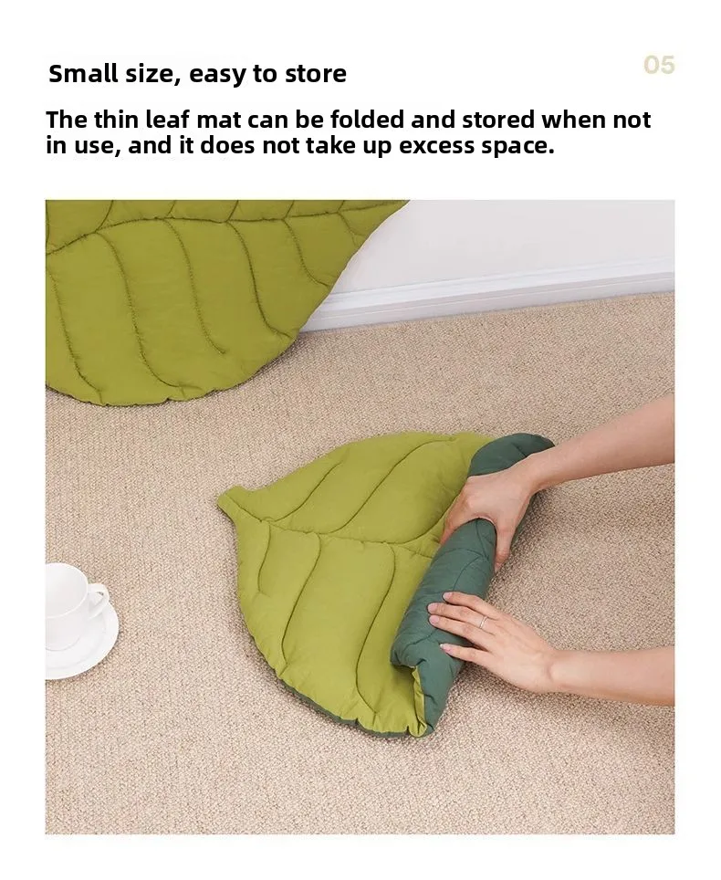 Hands rolling up a reversible Leaf Pattern Cat Sleeping Mat on a carpeted floor.