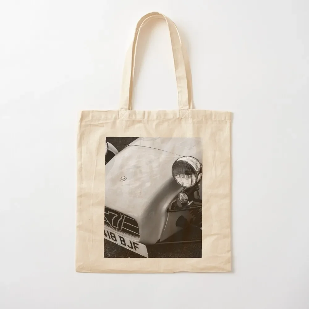 A black and white image of the front of a 1996 Caterham Super 7 on display at a car show Tote Bag shopping cart bags Tote Bag