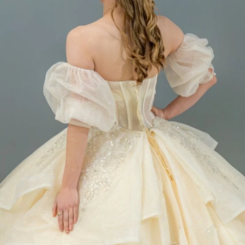 Helles Champagner-glänzendes Quinceanera-Kleid, Ballkleid, schulterfrei, Pailletten-Applikation, Spitze, Perlenstickerei, Schleife, Tüll, Korsett, Sweet-16-Kleid