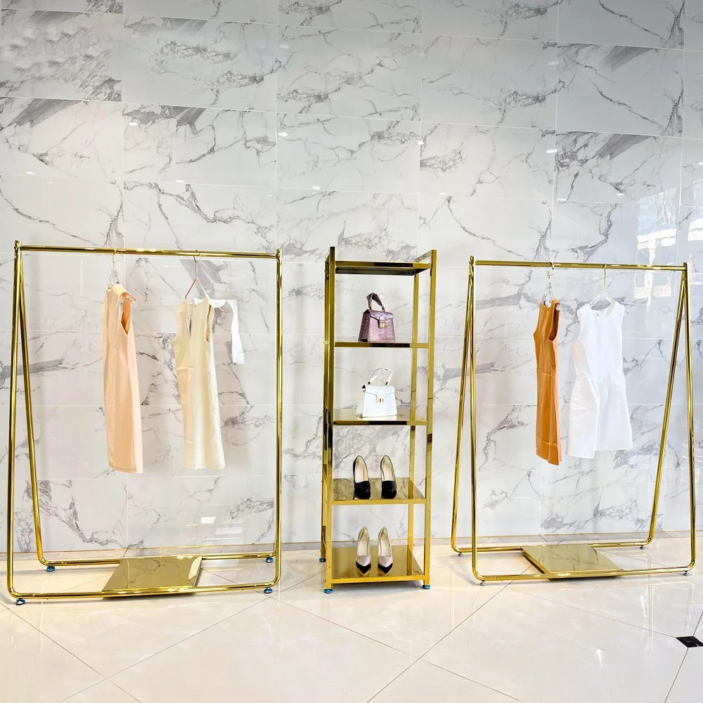 โต๊ะโชว์เสื้อผ้าดีไซน์ทันสมัยทำจากโลหะสีทองเงาสำหรับร้านค้าปลีกเสื้อผ้า ชั้นวางโชว์เสื้อผ้าสีทองสำหรับร้านขายเสื้อผ้า