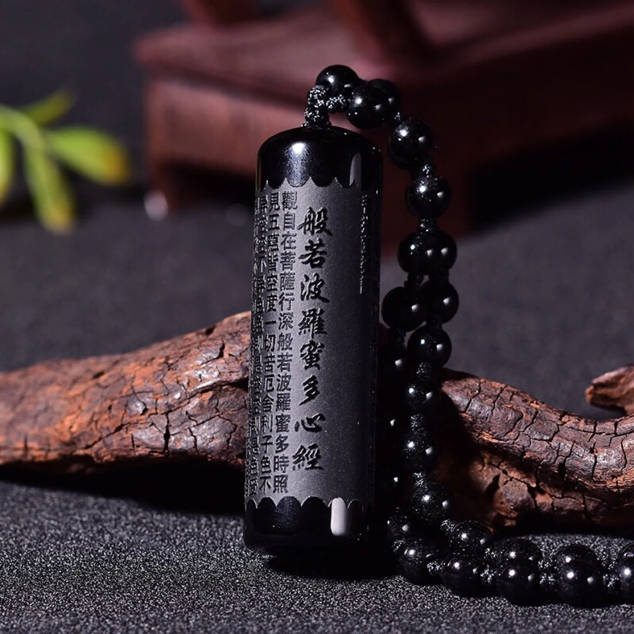 Natural obsidian prajna paramita pendant on a pillar