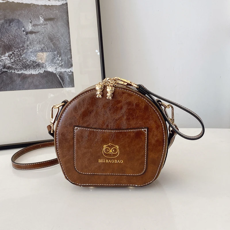 2025 بولي Leather حقيبة يد جلدية صغيرة شكل دائري حقيبة كتف الكرتون الطباعة حقيبة كروس الجسم العلامة التجارية تصميم حقيبة مقبض قصير للنساء