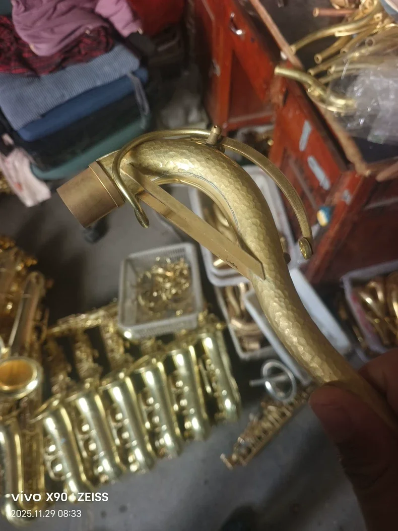 Golden saxophone bent neck, made of pure copper, with hammer patterns on the surface, and the gold plating process is intact