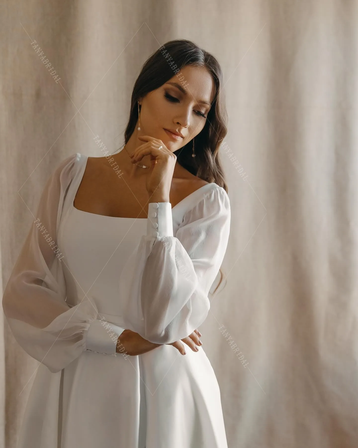 ชุดแต่งงานผ้าซาตินคอเหลี่ยม แขนยาว ทรงเอ ผ่าข้างสูง ชายกระโปรงยาวลากพื้น ดีไซน์หรูหรา