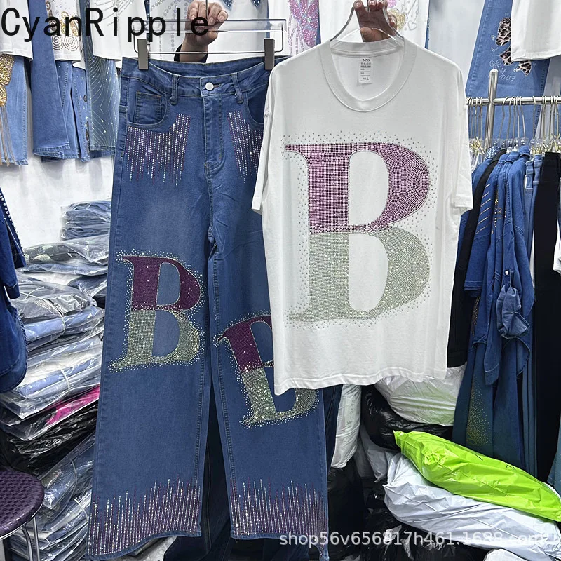 

Модный женский комплект из двух предметов для весны и лета: роскошная футболка с коротким рукавом, украшенная буквами и стразами, и прямые синие джинсы с высокой талией.