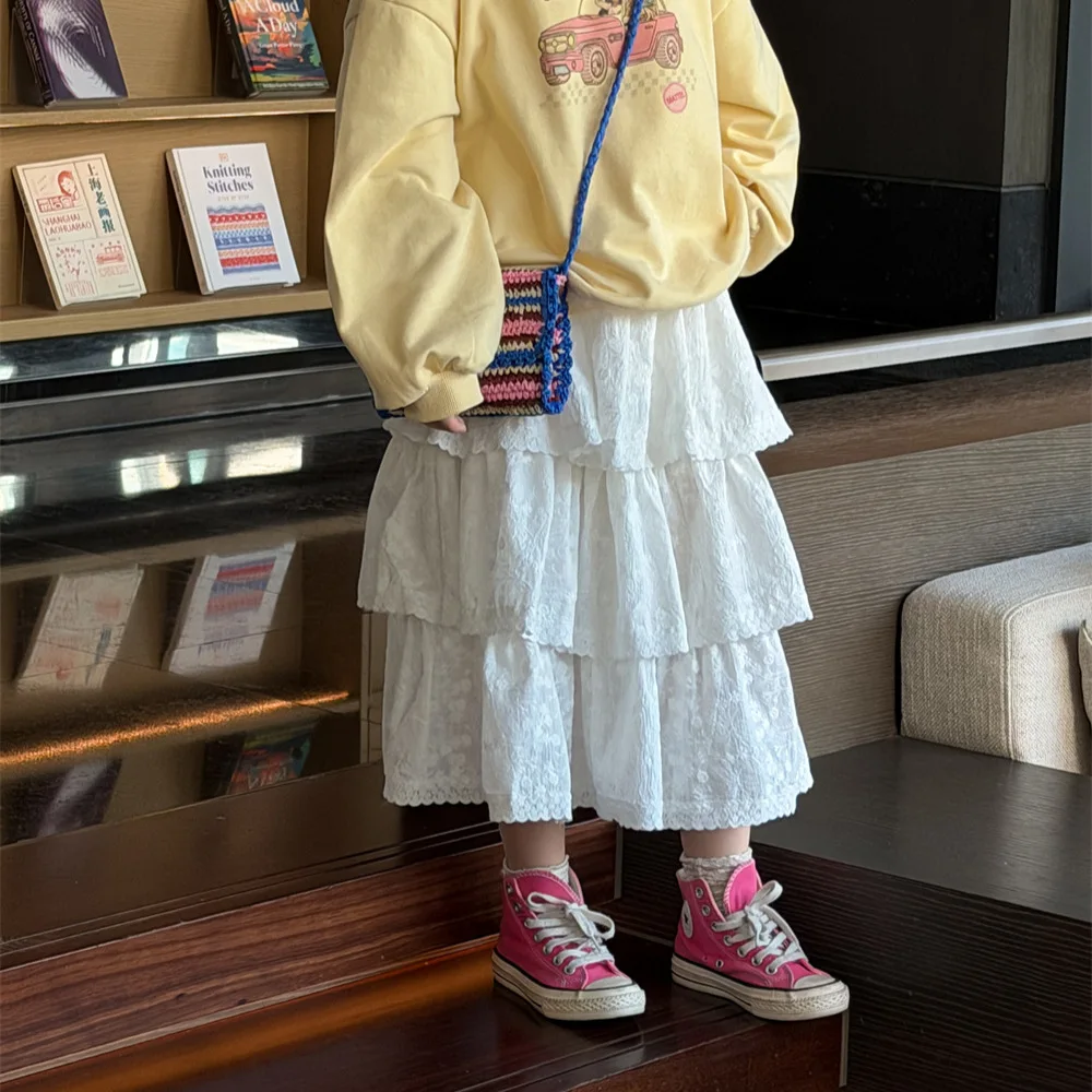 Saia Infantil Feminina 2026 Primavera Verão Nova Coleção Roupa Infantil Estilo Coreano Saia de Renda em Camadas para Meninas Design Simples e Moderno