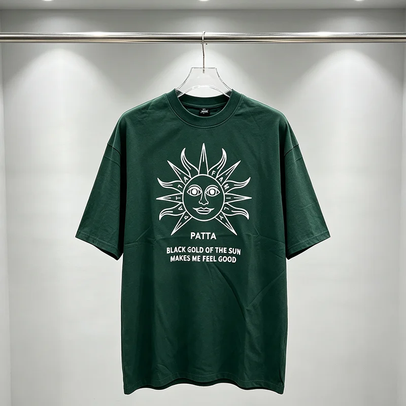 Camiseta de manga corta para hombre de la marca PATTA, con cuello redondo, estampado gráfico de un rostro solar y diseño «Black Gold of The Sun», de corte holgado y estilo casual.