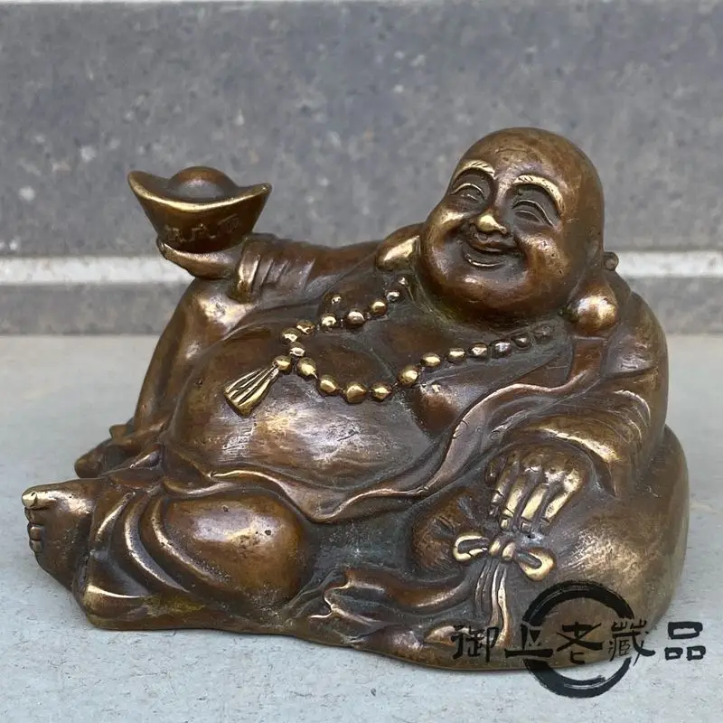 Brass craft big-bellied Maitreya Buddha with ingots in hand and a smile
