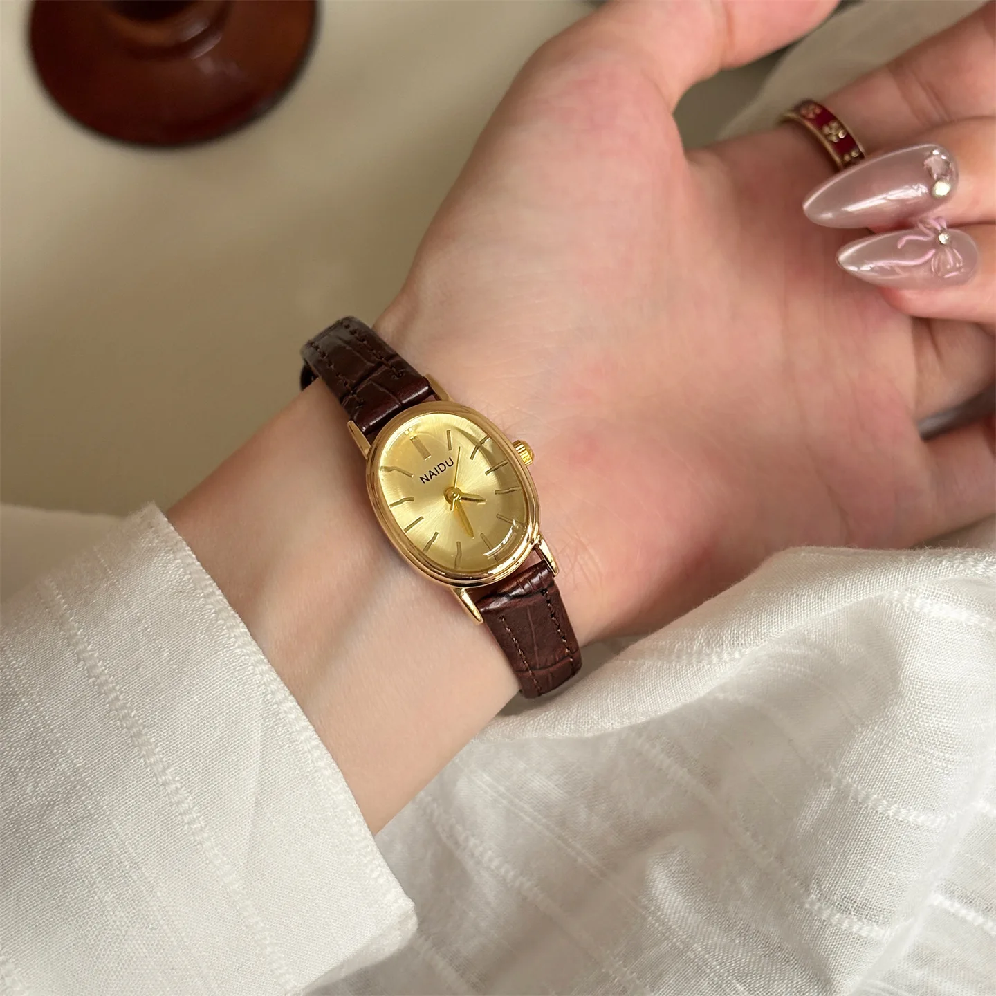 

NAIDUwatch Часы овальной формы для студенток с высоким внешним видом Компактные темпераментные нишевые и высококачественные кварцевые женские часы