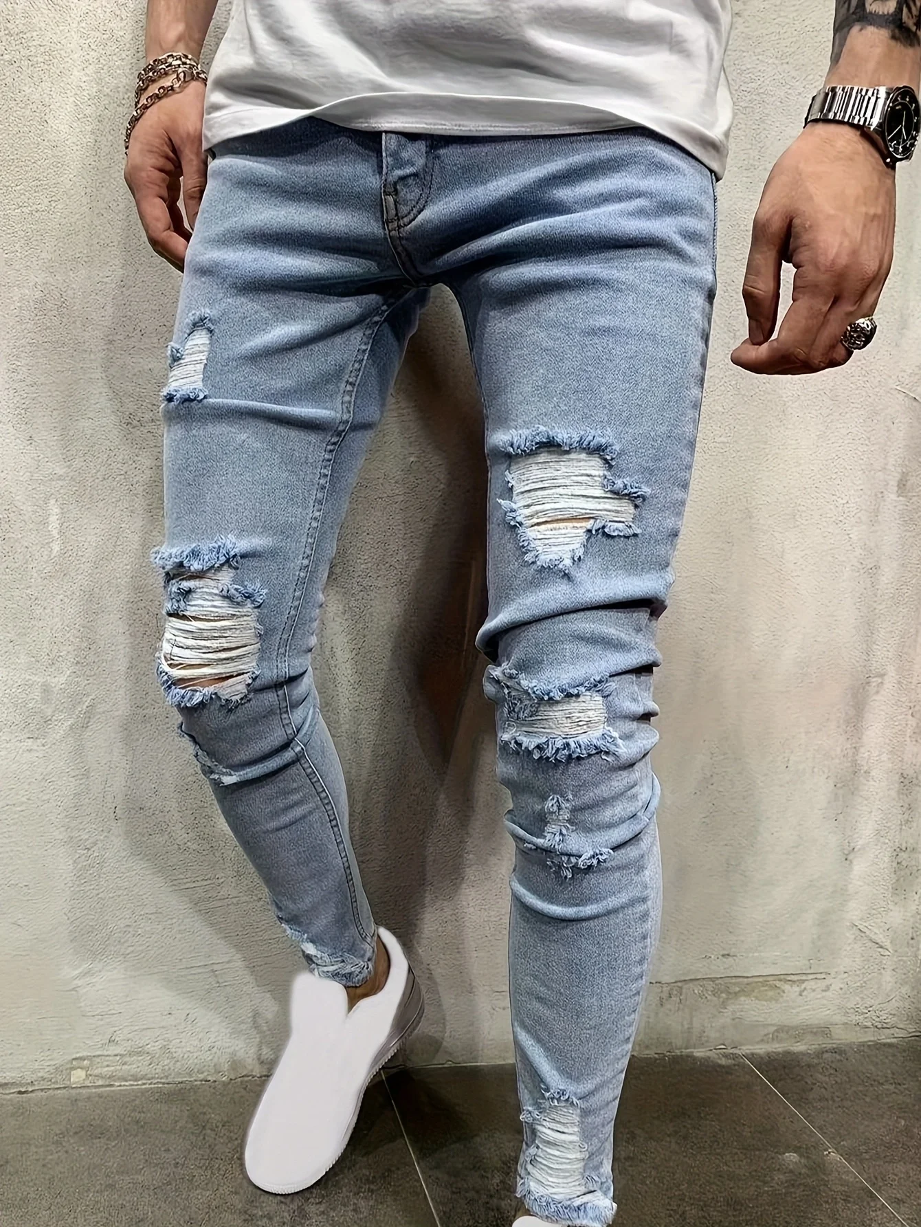 Men's Stretch Slim-fit Ripped Jeans, Featuring a Fashionable Street Style. These Blue Urban-style Jeans Are Versatile for Casual Outings, Leisure Activities, and Work. They Are Classic Blue Stretch Jeans with a Washed Finish and a Tapered Leg Design