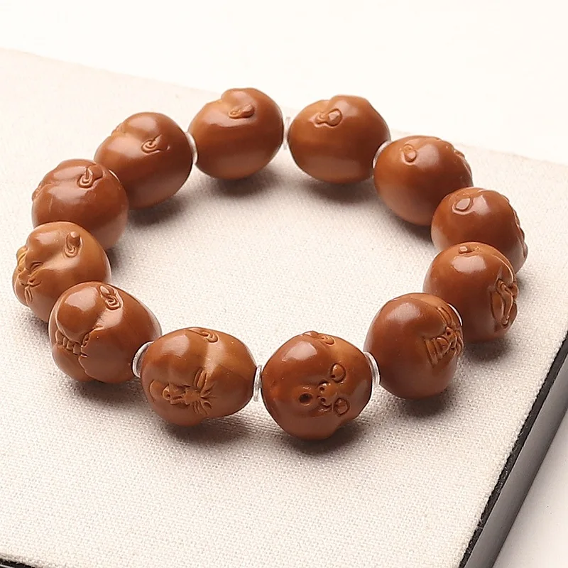 Olive pit charm bracelet, featuring a fun whimsical design, carved from iron ore, with a chubby, happy, and nearly perfectly