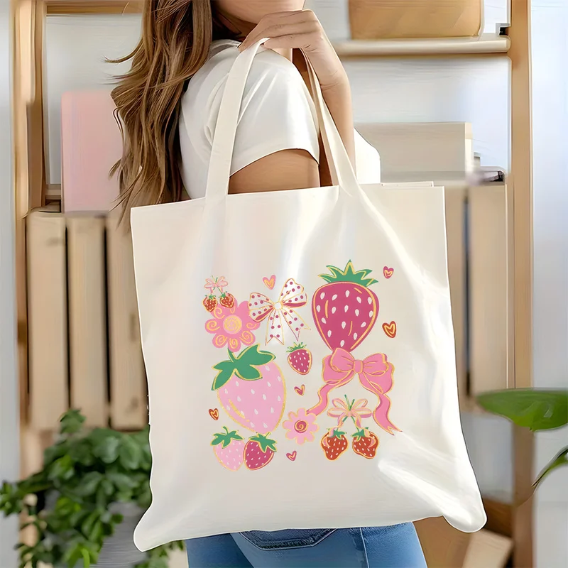 A strawberry bow handbag，Large-capacity cute pink strawberry print with heart shape and bow，Durable canvas shoulder bag，Suitable