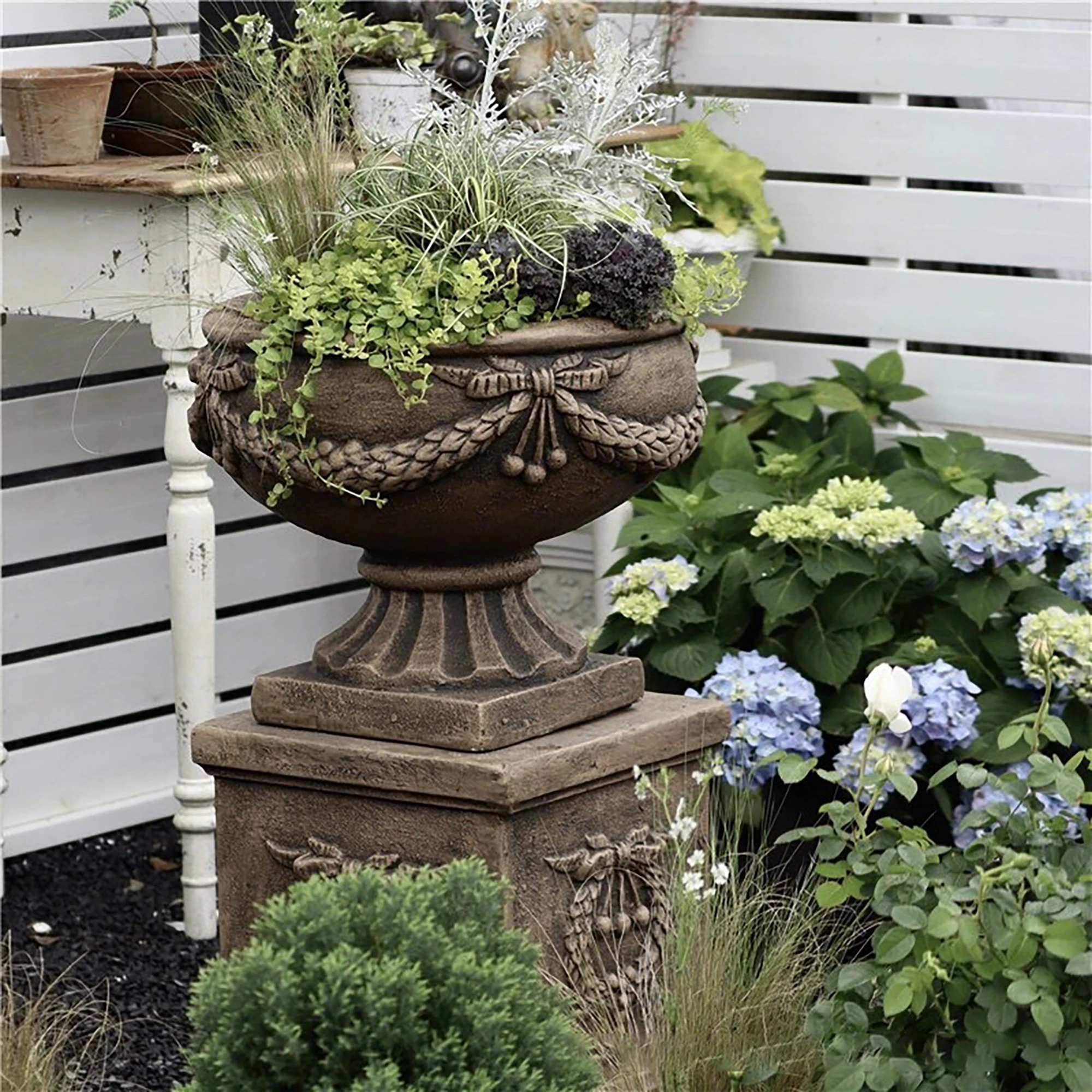 Large vintage cast stone flower pots and Roman columns rusted finish