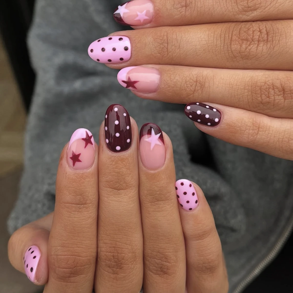 Dieses Nagelset enthält 24 einfache, mittelkurze, ovale Press-on-Nägel in Burgunderrot, verziert mit süßen und hübschen rosa Punkten und