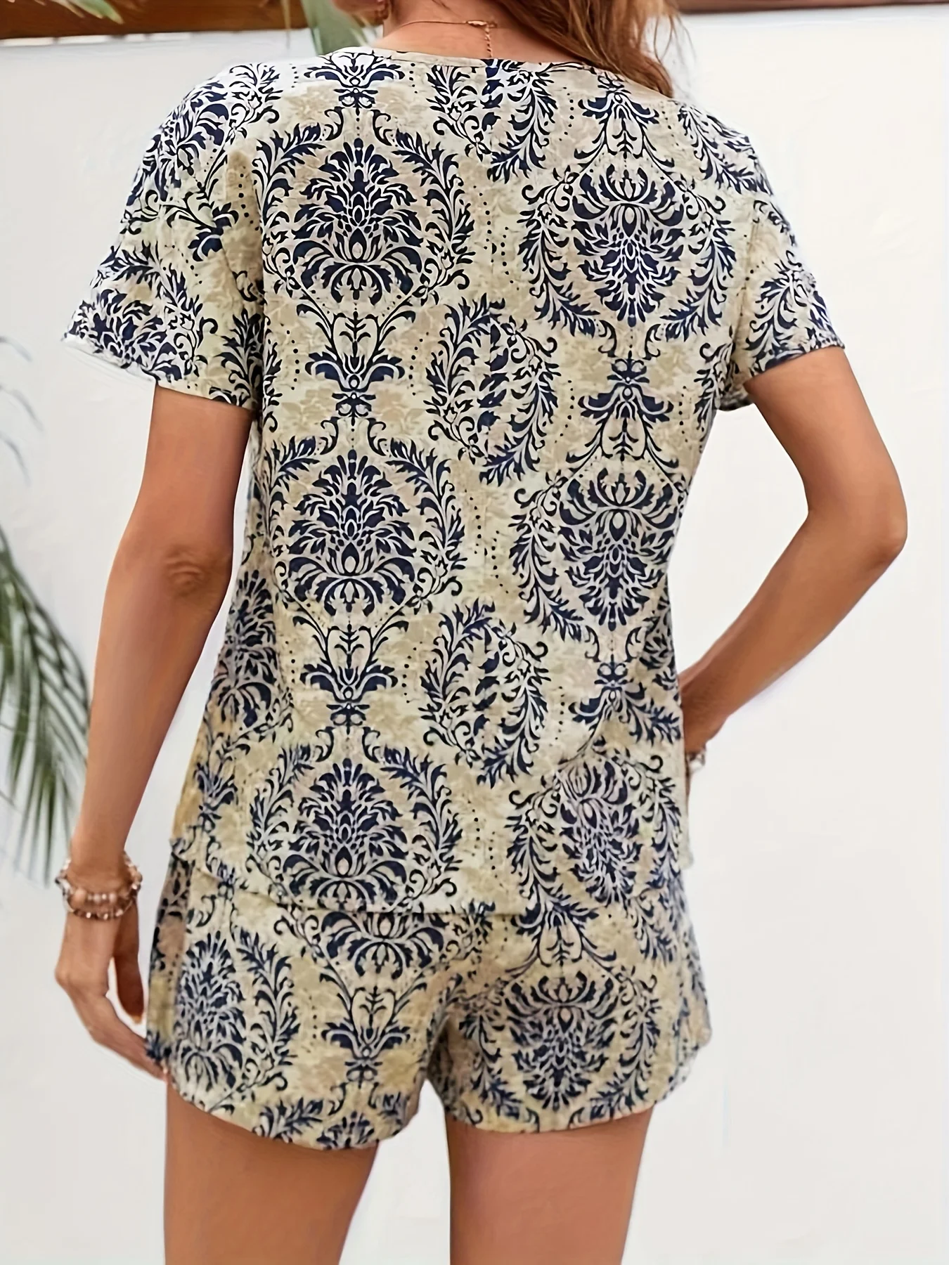A stylish women’s garment featuring a versatile V-neck, short sleeves, and printed design, paired with a comfortable, short two-