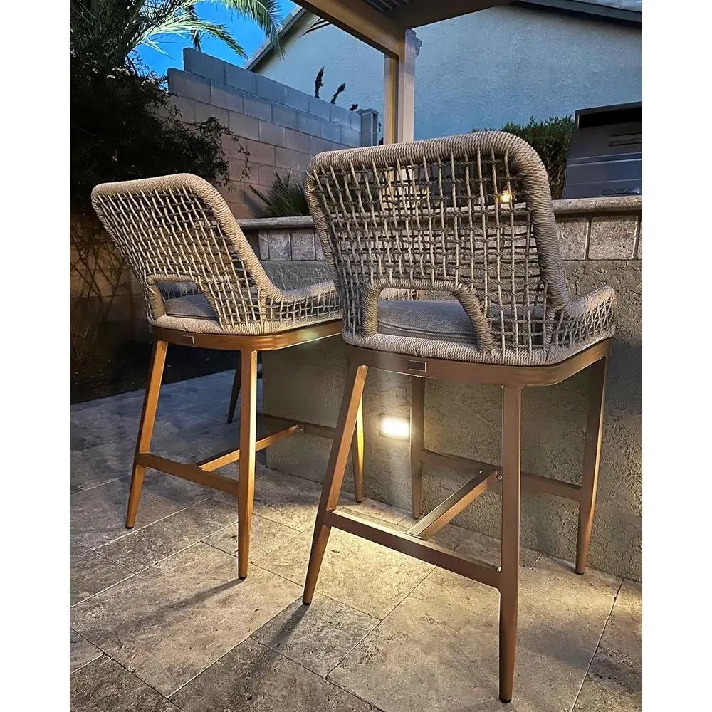 

Пара металлических барных стульев с плетеными спинками для использования на открытом воздухе, на террасе и в саду.
