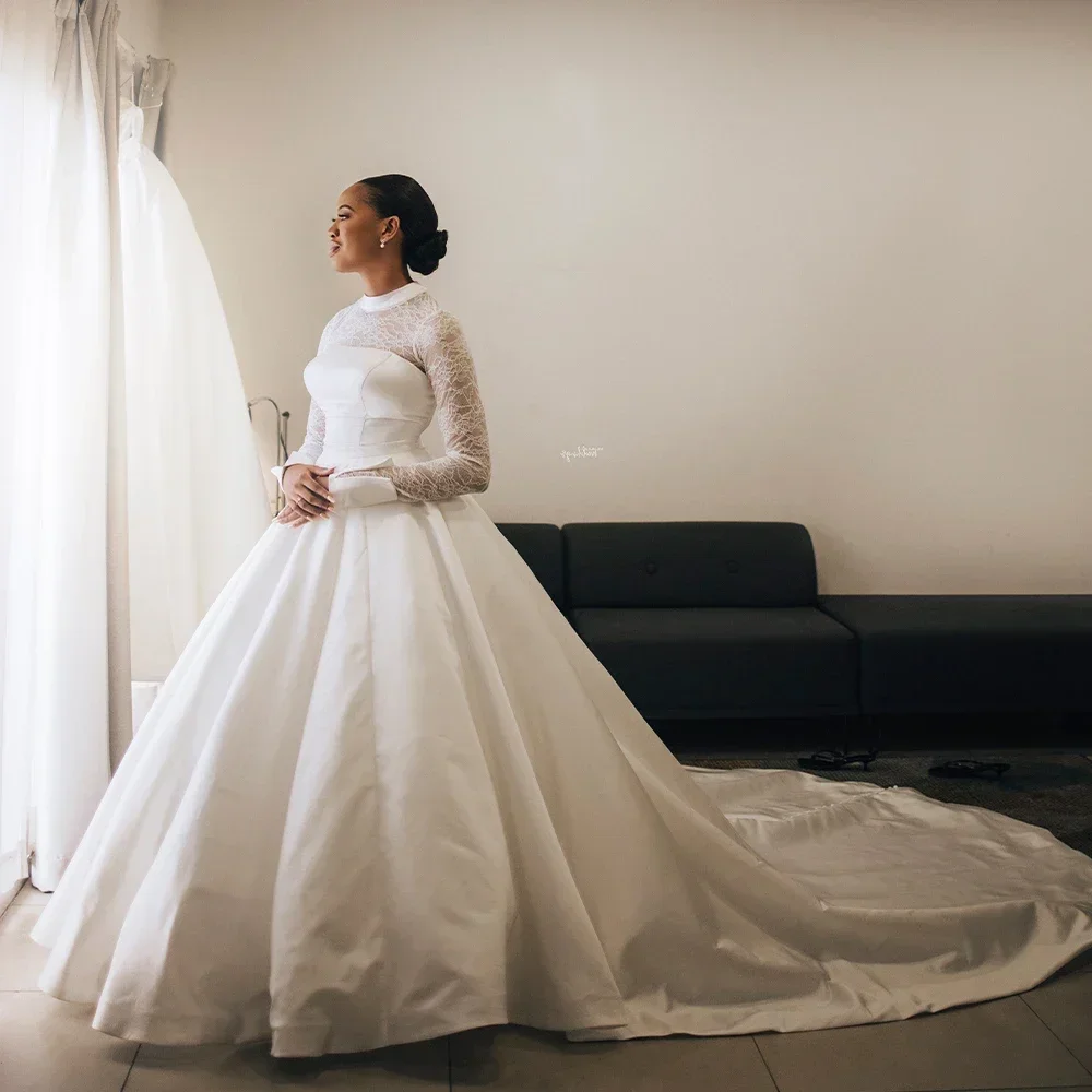 ชุดแต่งงานคอสูงแขนยาวลูกไม้แบบกำหนดเอง ชุดแต่งงานทรงบอลกาวน์พองๆ ผ้าซาตินจับจีบชายกระโปรงยาวแบบ Chapel Train