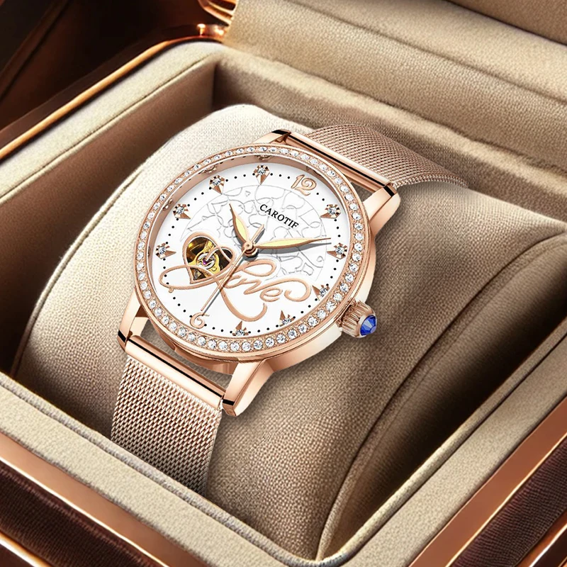 

Женский элегантный корпус из розового золота с белым циферблатом и ремешком из розовой стали в форме сердца. Механические часы.