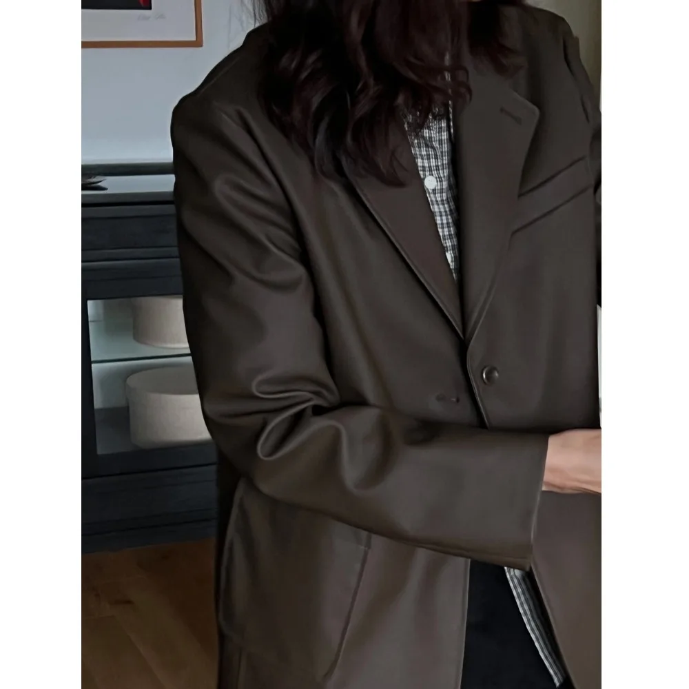 Długi płaszcz ze skóry PU z luźnym krojem i kołnierzem garniturowym, modna odzież wierzchnia dla młodych kobiet na sezon jesienny.