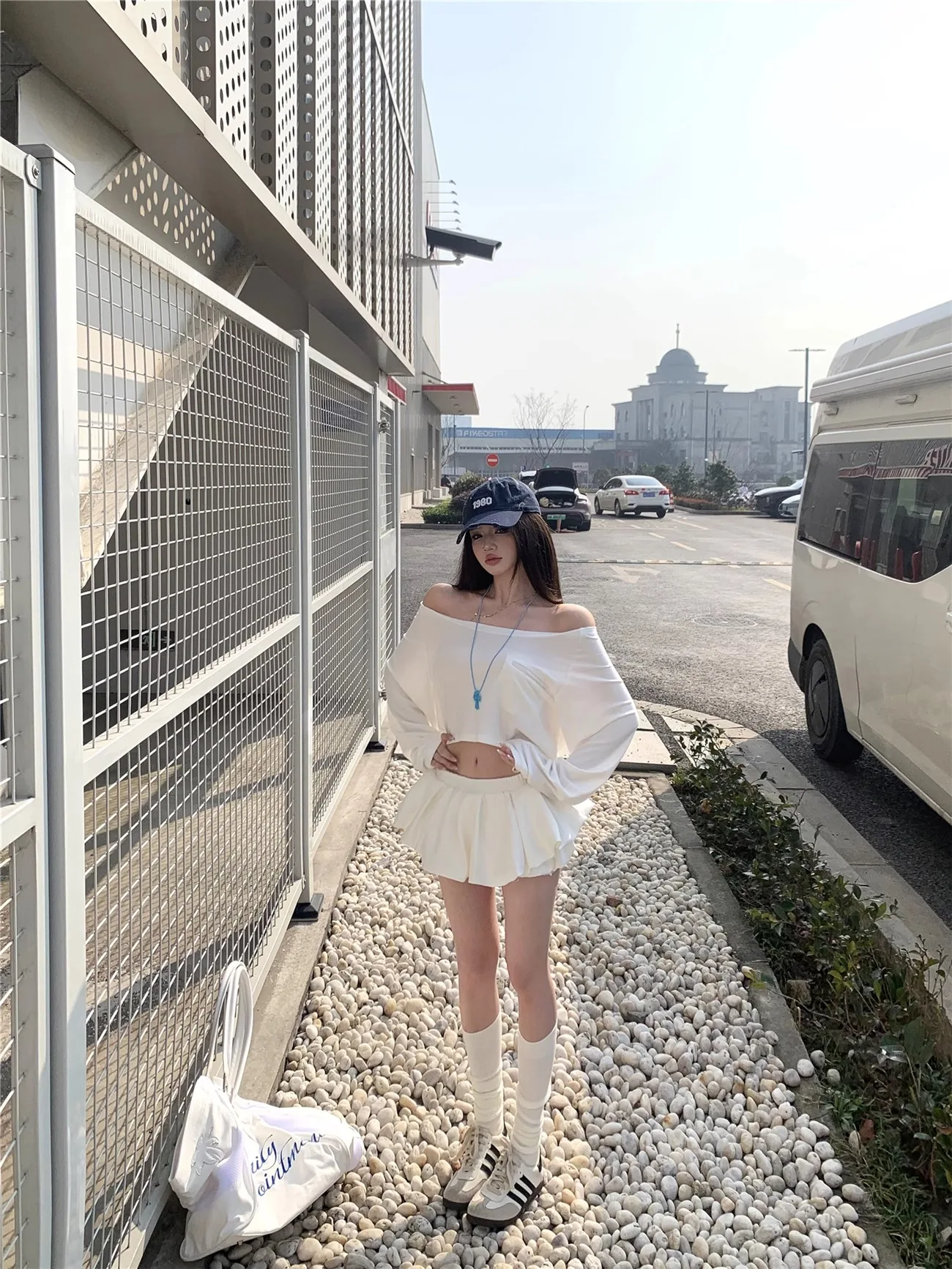Set atasan dan rok kasual wanita untuk musim panas, model satu bahu warna putih dengan rok lipit, setelan dua potong.