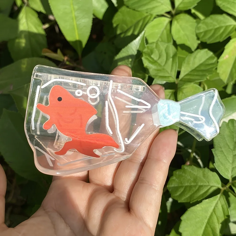 تصميم لخزان الأسماك الشفافة على شكل سمكة ذهبية، تصميم ممتع لخزان الأسماك باللون البرتقالي والأزرق، مناسب لتصفيف الشعر غير الرسمي