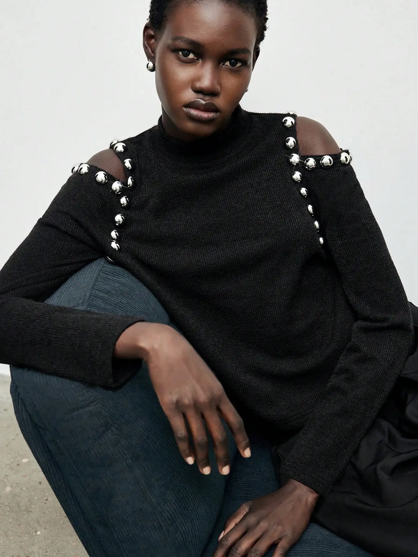 

Черный вязаный топ с открытыми плечами, серебряными заклепками, длинными рукавами и круглым вырезом