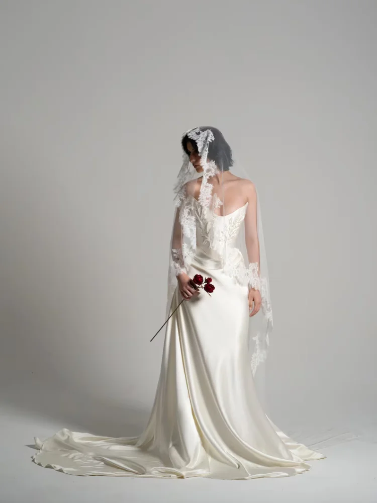 Suknia ślubna katedralna z satyny w kolorze białej kremowej, drapowana, z gorsetem w talii, z trenem do ziemi, model 2025, szyta na miarę.