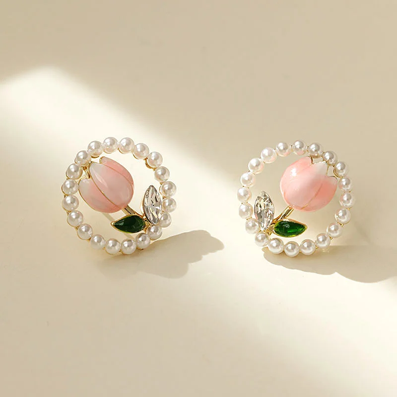 A pair of elegant alloy floral earrings with acrylic pearls and green leaves, and stylish sparkling tulip studs, perfect as a bi