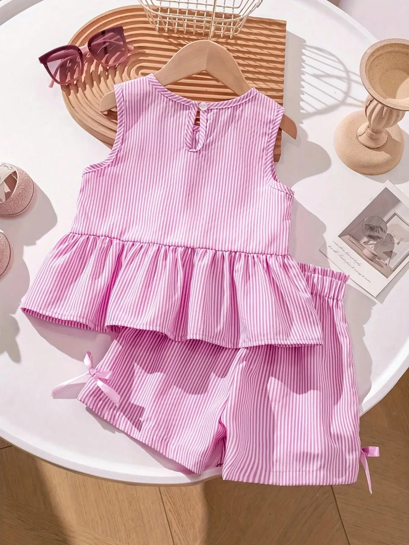 Modisches zweiteiliges Set für Mädchen: rosa-weiß gestreifter Rundhalspullover mit Schnürung, Schleife und Rüschenrand + rosa gestreifte Schmetterlings-Shorts. – Detail 3