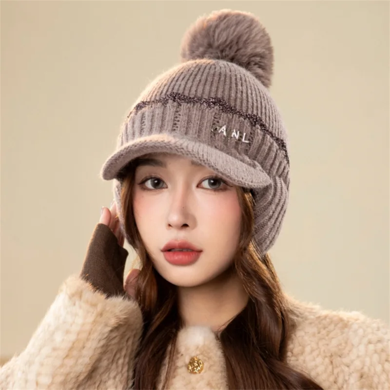 Korean style knitted hat for women. Warm in winter with rabbit fur ear flaps. Fashionable, thickened and has a pompom.