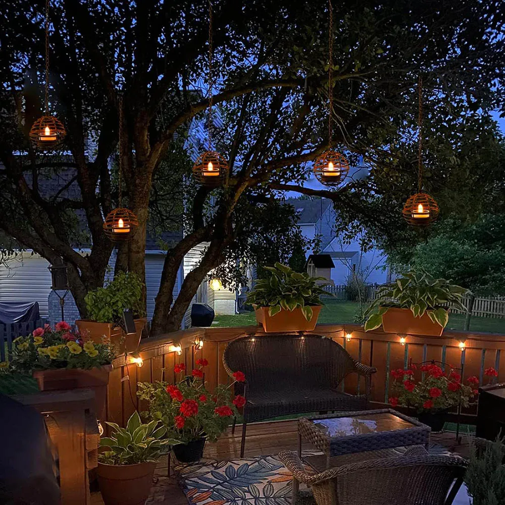 Komorebi solar iron ball lantern illuminated at night with flickering candle glow