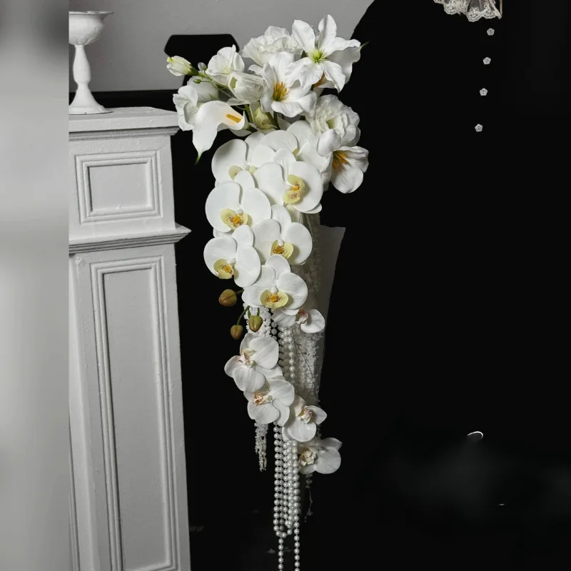 nicchia-bianca-simulata-cascata-bouquet-a-mano-elegante-abito-da-sposa-originale-fotografia-foto-perla-phalaenopsis-tenuta-a-mano